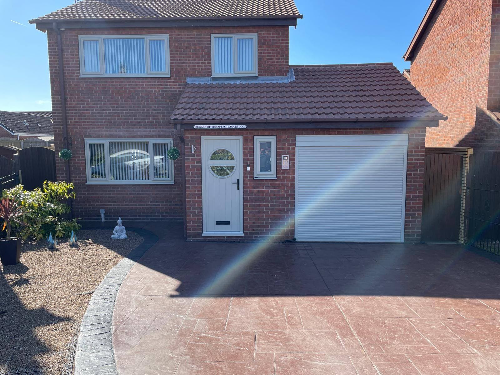 Front elevation of a brick home with a freshly finished garage door and matching entrance.
